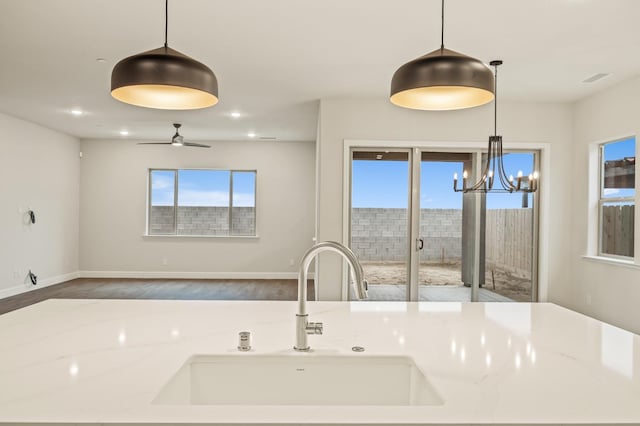 kitchen with a wealth of natural light, pendant lighting, a sink, and recessed lighting