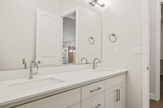 full bathroom with wood finished floors, a sink, and double vanity