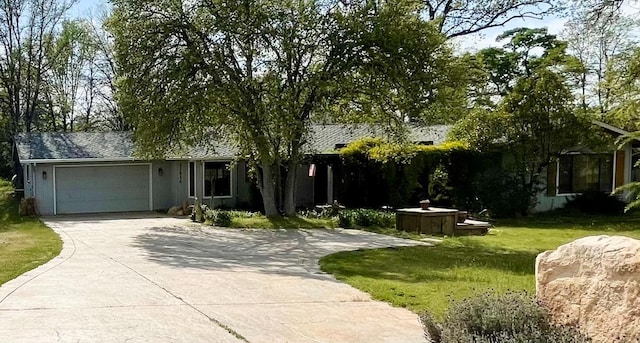 single story home featuring an attached garage, driveway, and a front lawn