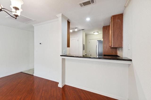 7178 N Fruit Ave Unit 132, Fresno, CA 93711 - kitchen with freestanding refrigerator, brown cabinetry, and visible vents