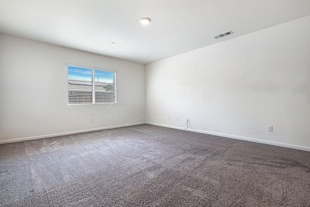 carpeted empty room featuring baseboards