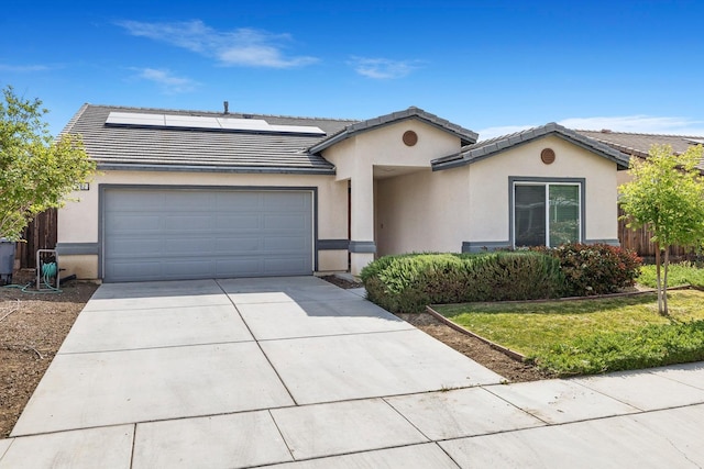 single story home featuring concrete driveway, stucco siding, an attached garage, roof mounted solar panels, and a tile roof