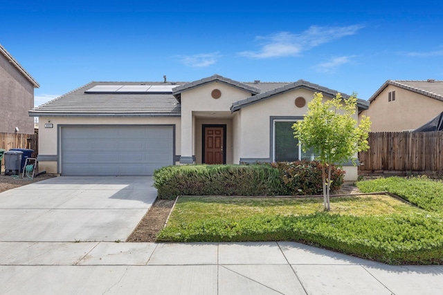 ranch-style house with an attached garage, stucco siding, a tile roof, driveway, and roof mounted solar panels