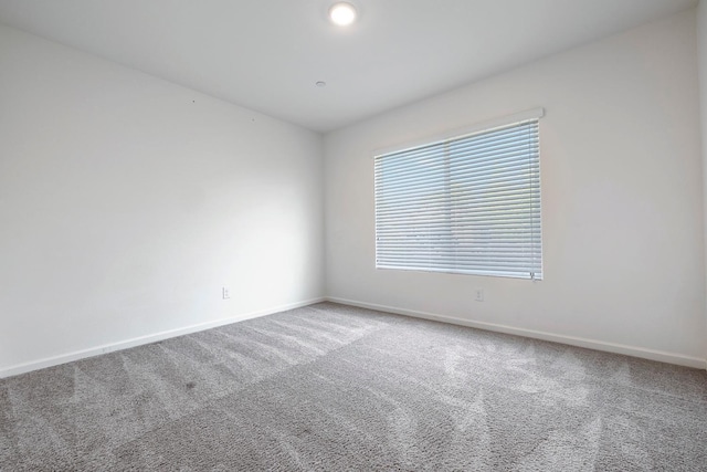 carpeted empty room with baseboards