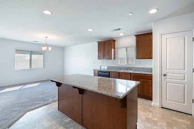 kitchen with dishwasher, a sink, a breakfast bar, a kitchen island, and light stone counters