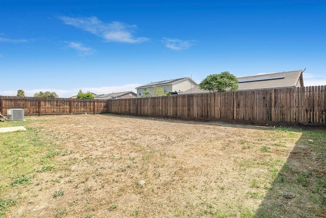 fenced backyard featuring central AC unit