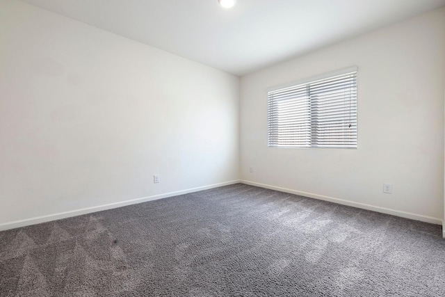 carpeted empty room featuring baseboards