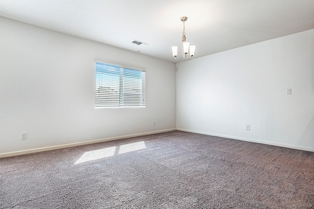 carpeted spare room with a chandelier and baseboards