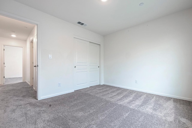 unfurnished bedroom featuring carpet, baseboards, and a closet