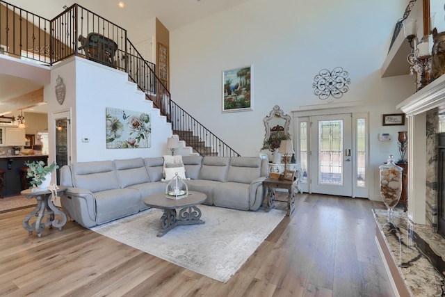 living area with wood finished floors, a high ceiling, and stairway