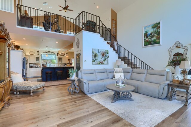 42038 Empty Creek Rd, Oakhurst, CA 93644 - living area featuring ceiling fan, light wood finished floors, a towering ceiling, and stairs