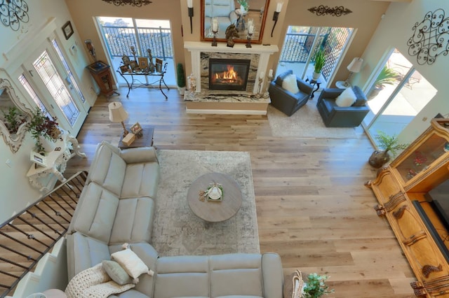 living room with a stone fireplace and wood finished floors