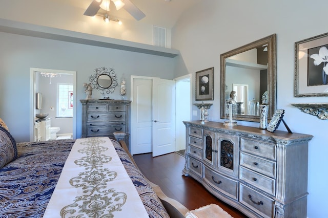 bedroom with visible vents, dark wood-style flooring, lofted ceiling, ensuite bathroom, and a ceiling fan