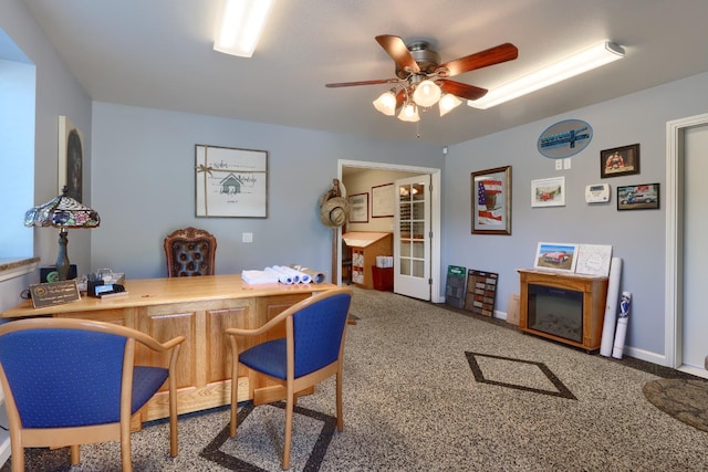 office space featuring a ceiling fan, baseboards, and carpet