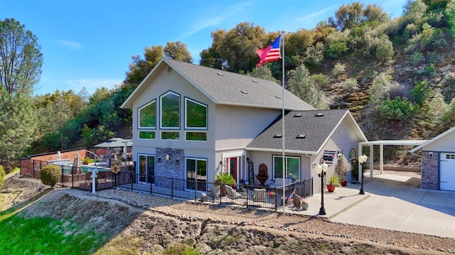 rear view of property with fence, a patio, stucco siding, and a shingled roof