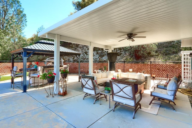 view of patio / terrace featuring fence, a gazebo, an outdoor living space, and ceiling fan