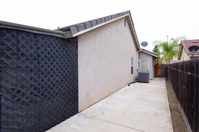 view of property exterior featuring a patio area, central AC unit, a fenced backyard, and stucco siding