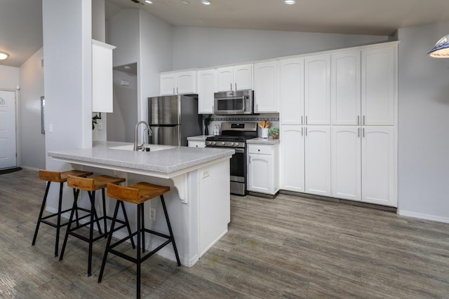 kitchen with white cabinets, a breakfast bar area, a peninsula, and appliances with stainless steel finishes