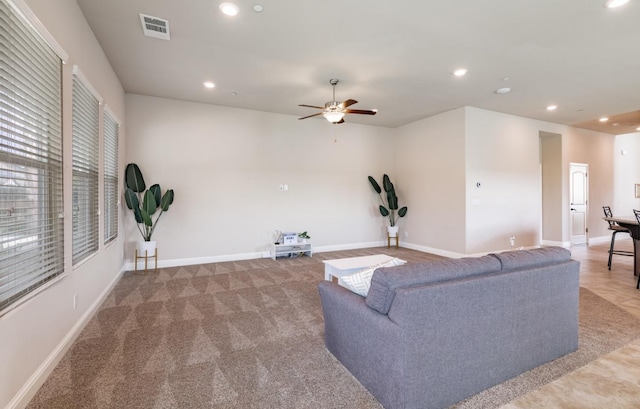 living area featuring baseboards, a ceiling fan, visible vents, and recessed lighting