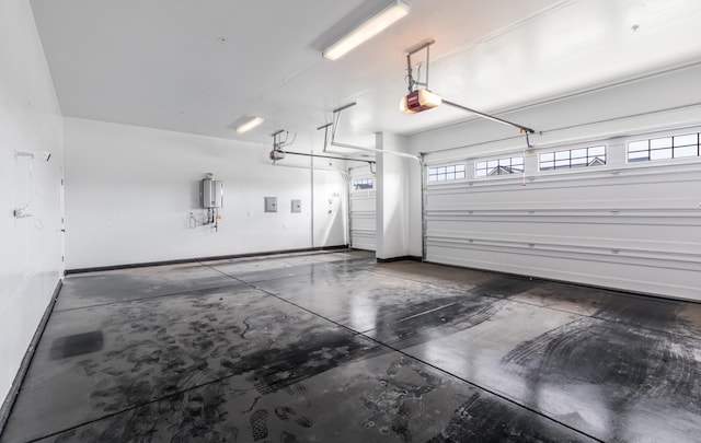 garage featuring a garage door opener and baseboards