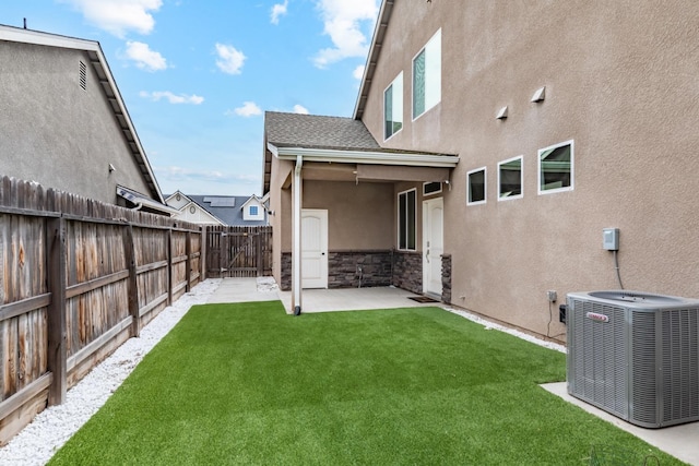 view of yard featuring a fenced backyard, central AC, and a patio