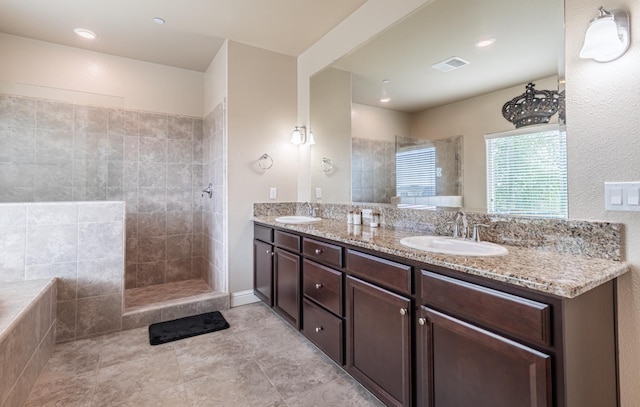 full bathroom featuring double vanity, tile patterned floors, a walk in shower, and a sink