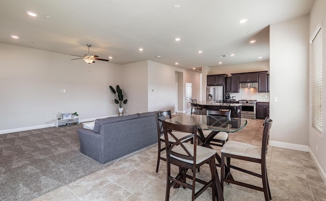 dining room featuring ceiling fan, baseboards, light carpet, and recessed lighting