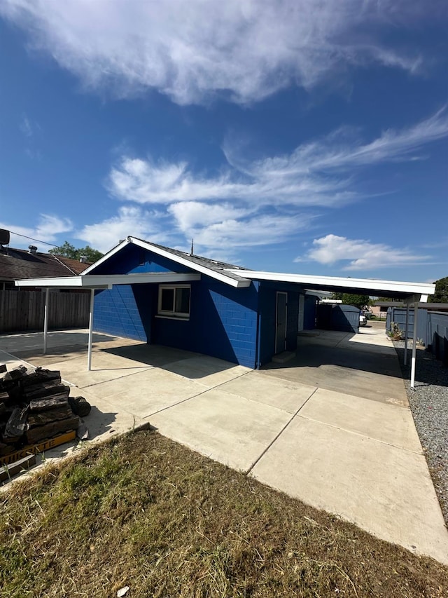 exterior space with a carport, fence, and concrete driveway