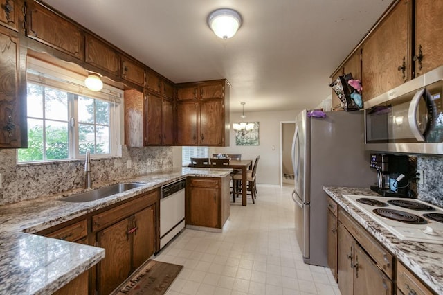 7341 N Bond St, Fresno, CA 93720 - kitchen with backsplash, brown cabinetry, a sink, and white appliances