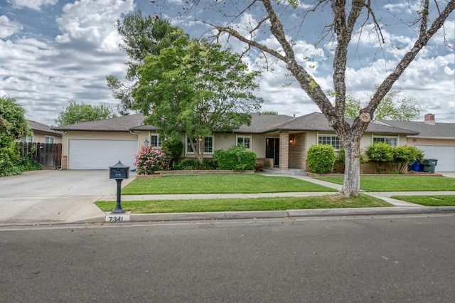 7341 N Bond St, Fresno, CA 93720 - ranch-style home featuring driveway, an attached garage, fence, a front yard, and stucco siding