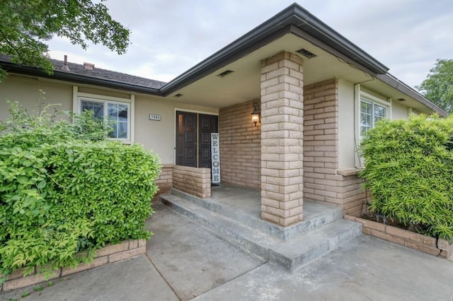 7341 N Bond St, Fresno, CA 93720 - property entrance with stucco siding, brick siding, and covered porch