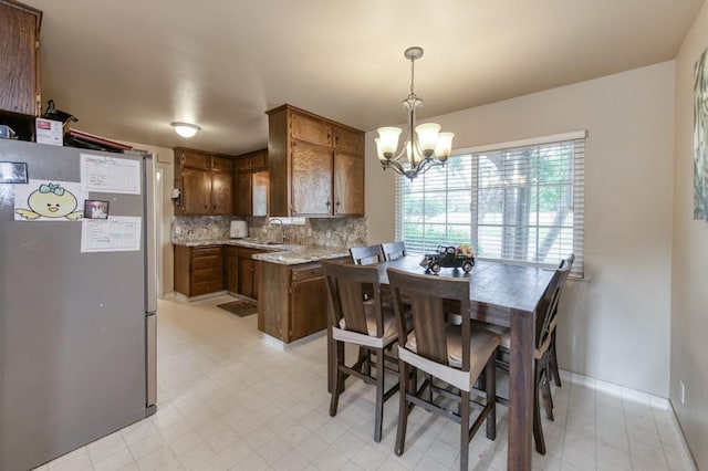 7341 N Bond St, Fresno, CA 93720 - dining space featuring light floors, baseboards, and a notable chandelier