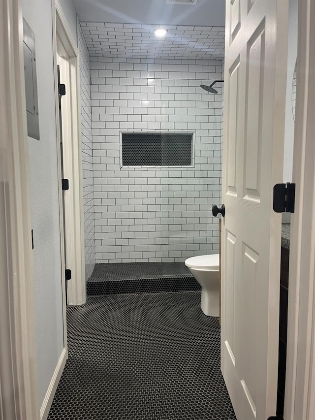 1151 S Chestnut Ave Unit 146, Fresno, CA 93702 - bathroom with toilet, baseboards, tiled shower, tile patterned floors, and electric panel