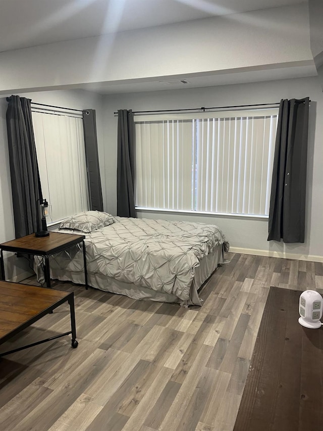 bedroom featuring baseboards and wood finished floors