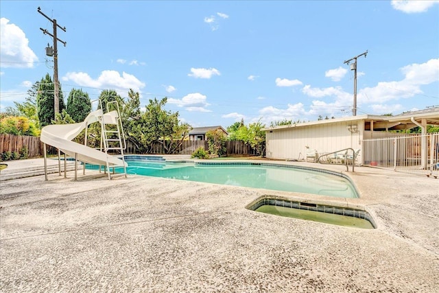 view of swimming pool with a fenced in pool, a fenced backyard, a water slide, a patio area, and a hot tub