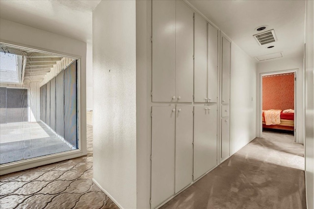 hall with carpet flooring and visible vents