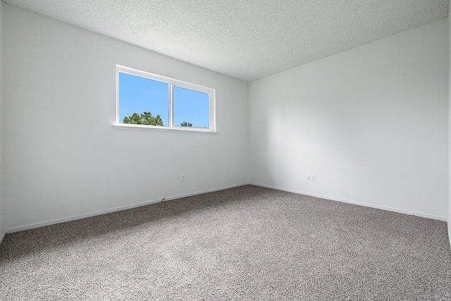 carpeted spare room with baseboards and a textured ceiling