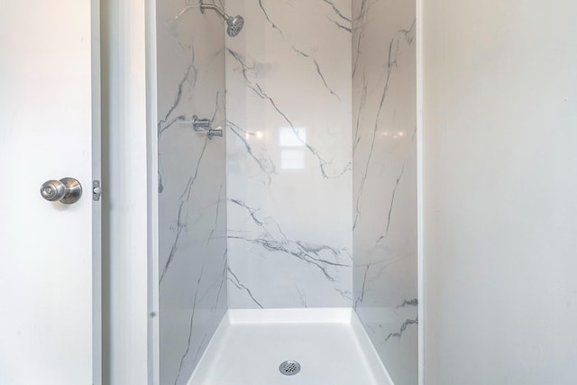 bathroom featuring a marble finish shower