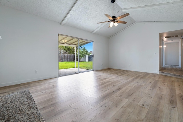interior space featuring light wood finished floors, a textured ceiling, visible vents, lofted ceiling, and a ceiling fan