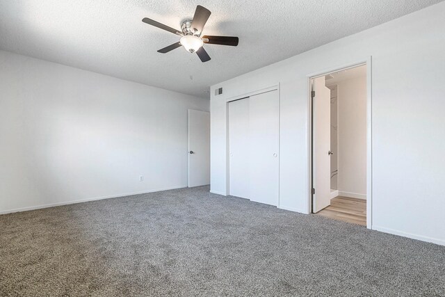 unfurnished bedroom featuring a ceiling fan, a textured ceiling, a closet, carpet floors, and visible vents