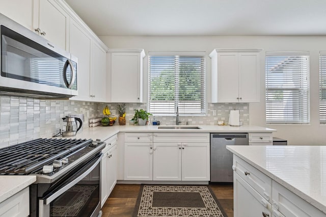 6082 E Homan Ave, Fresno, CA 93727 - kitchen with appliances with stainless steel finishes, white cabinets, decorative backsplash, and dark wood-type flooring