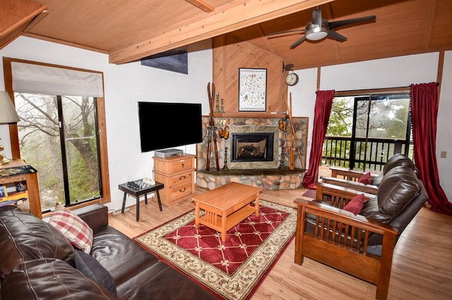 40720 Oakwoods Ln, Shaver Lake, CA 93664 - living room with wood ceiling, wood finished floors, a ceiling fan, vaulted ceiling with beams, and a stone fireplace