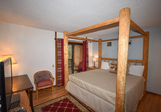 40720 Oakwoods Ln, Shaver Lake, CA 93664 - bedroom featuring a textured ceiling, access to exterior, and wood finished floors