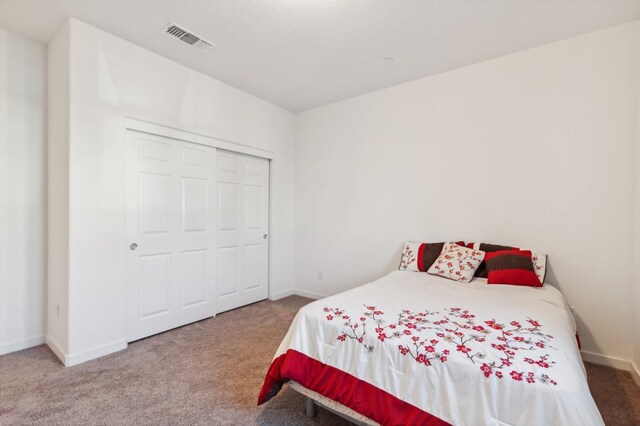 carpeted bedroom featuring baseboards and visible vents