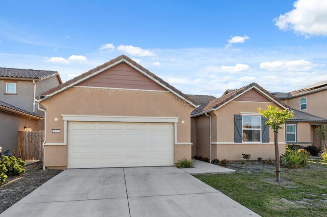 ranch-style home featuring a tile roof, driveway, fence, a garage, and stucco siding