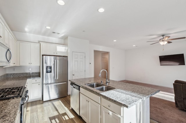 kitchen featuring stainless steel appliances, a sink, open floor plan, visible vents, and a ceiling fan