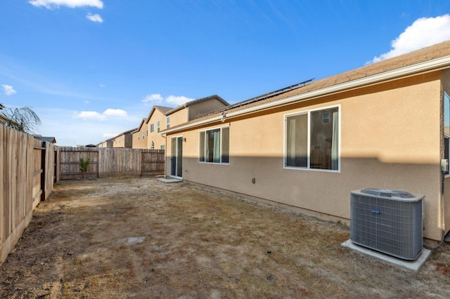 exterior space featuring a fenced backyard, central AC, and stucco siding
