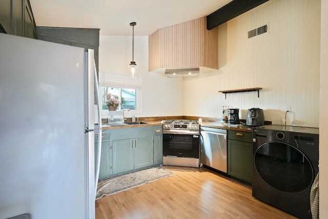1016 N White St, Hanford, CA 93230 - kitchen featuring range hood, a sink, washer / dryer, appliances with stainless steel finishes, and visible vents