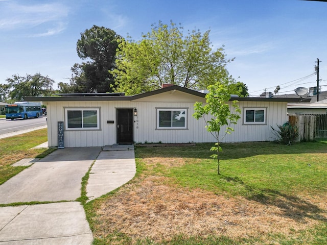 1016 N White St, Hanford, CA 93230 - ranch-style home with concrete driveway, fence, board and batten siding, and a front yard