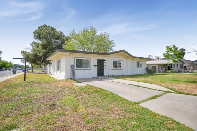 1016 N White St, Hanford, CA 93230 - view of front of property featuring fence, driveway, a front lawn, and board and batten siding